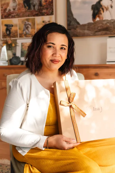 Pet photography client packaging, Ina holding a branded presentation box tied with a ribbon